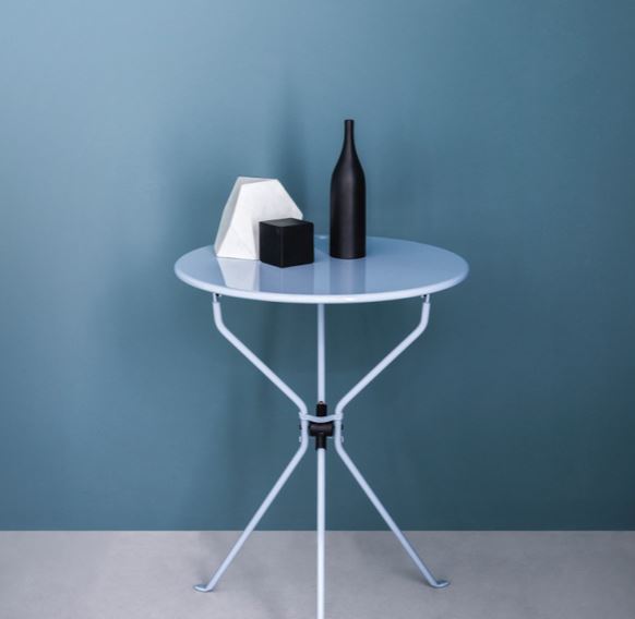 Table pliante Cumano Ø55 cm par Achille Castiglioni - Zanotta-en situation, portant une bouteille et une boîte-The Woods Gallery