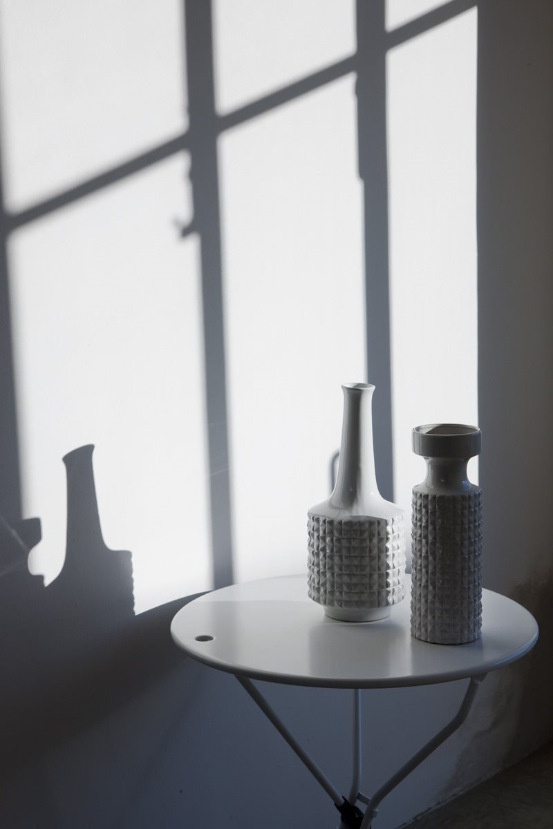 Table pliante Cumano Ø55 cm par Achille Castiglioni - Zanotta-plateau blanc portant deux vases, ombres de fenêtre-The Woods Gallery