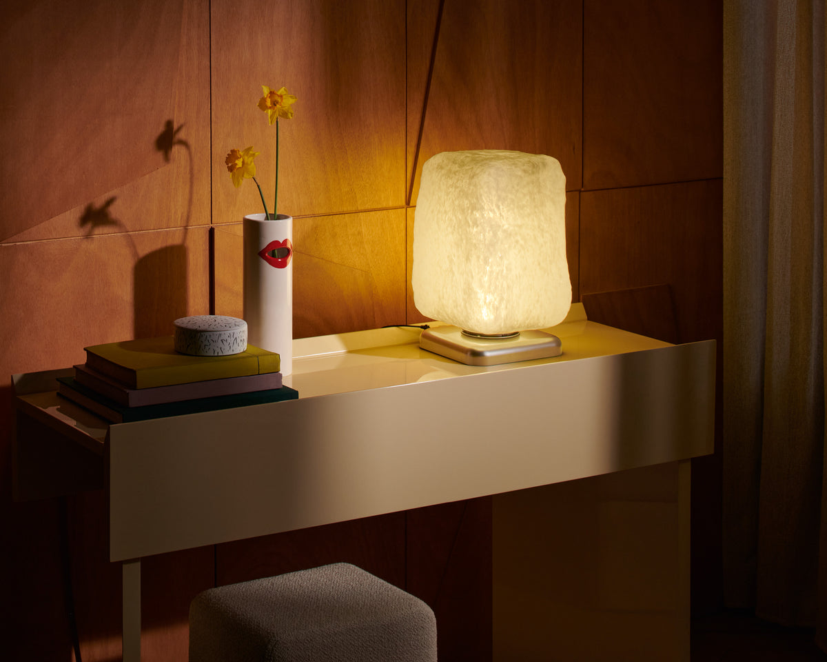 Lampe à poser Wax, Stone, Light de Linde Freya Tangelder - Cassina-allumée sur une console, avec vase et livres-Cassina