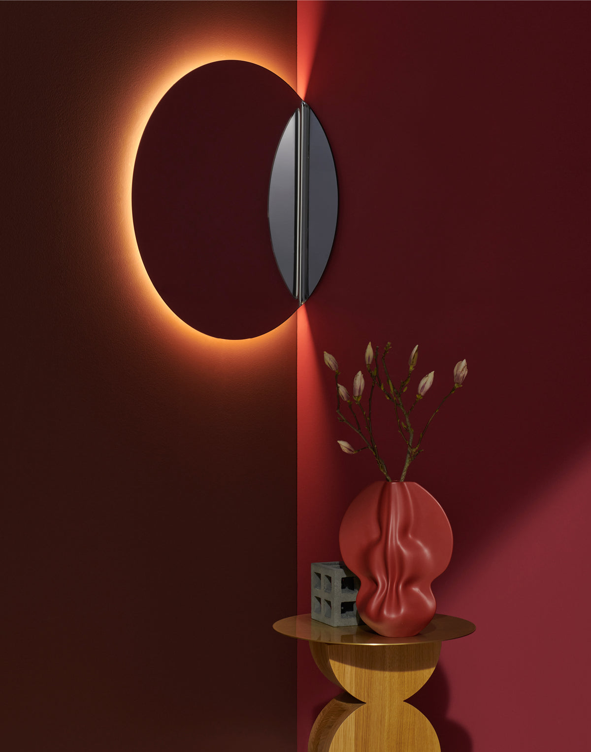Miroir Gibbous de Michael Anastassiades - Cassina-miroir rond rétroéclairé sur mur rouge, avec un vase-Cassina