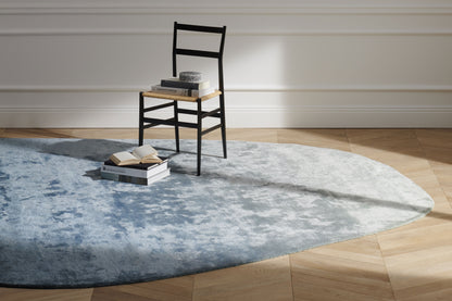 Tapis Aral en soie de bambou - Cassina-en situation sur parquet, tapis bleu et chaise noire-Cassina