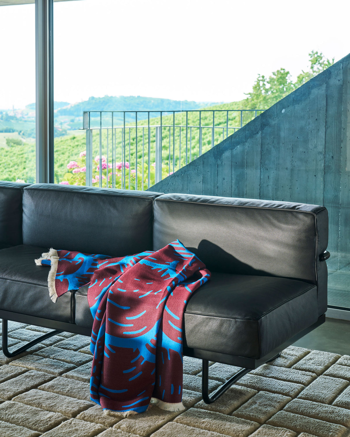 Plaid Toncloud de Patricia Urquiola - Cassina-plaid rouge et bleu sur un canapé en cuir-Cassina
