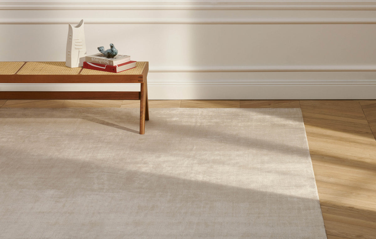 Tapis Atacama 3 en soie de bambou - Cassina-tapis beige clair devant un banc en bois et cannage-Cassina