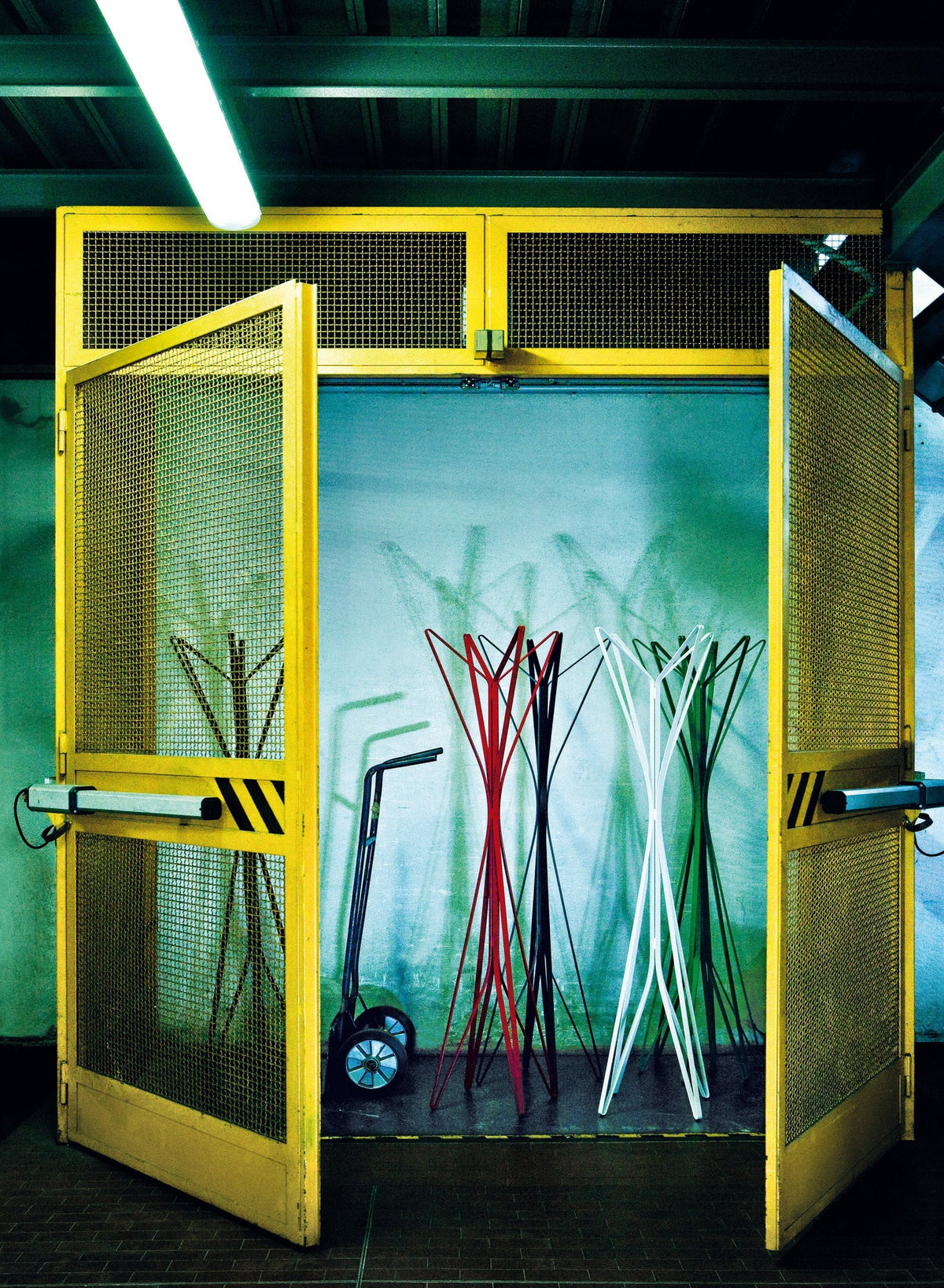 Porte-manteaux Aster 4 branches, Alessandro DUBINI, - Zanotta-en situation dans une armoire vitrée jaune-The Woods Gallery