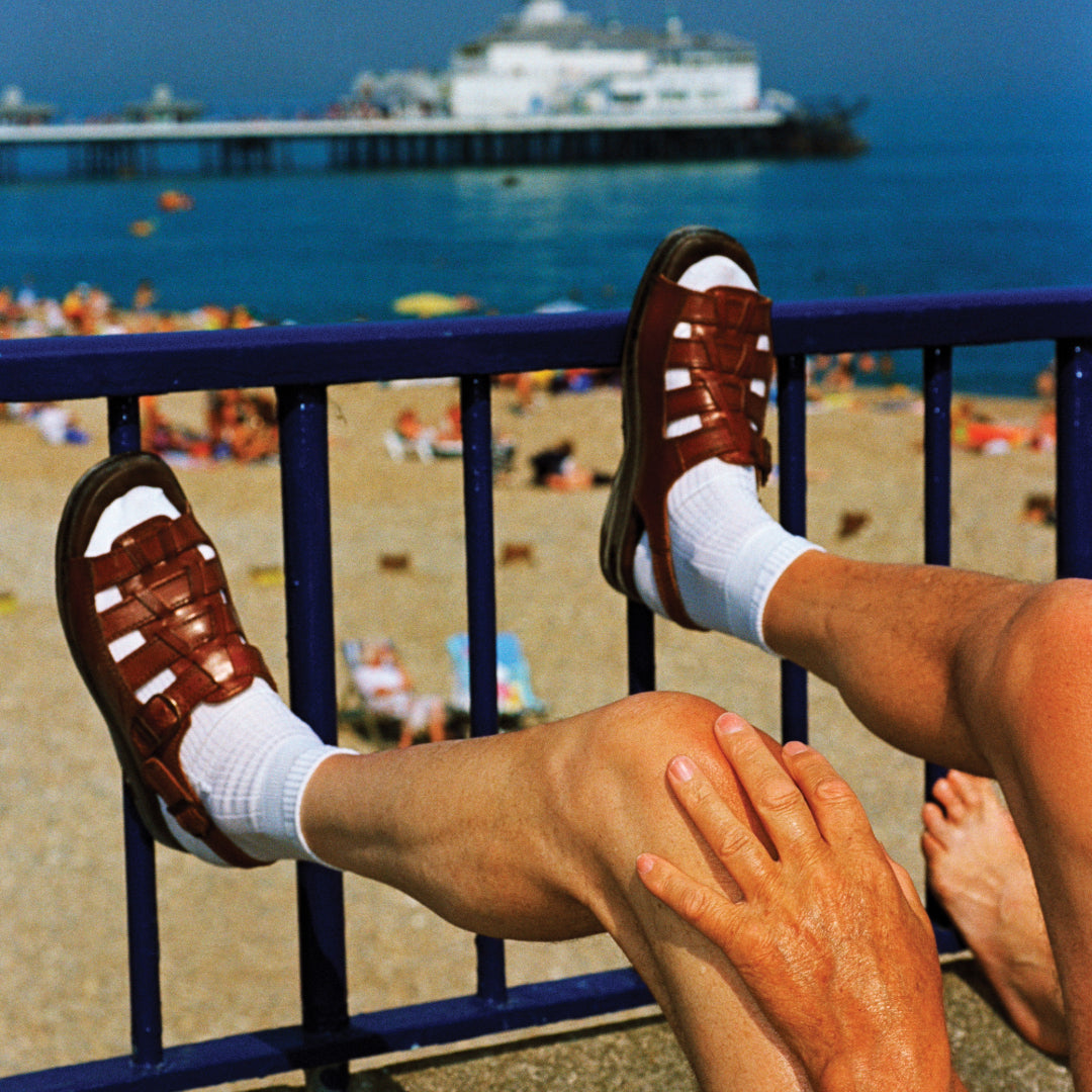 Affiche EASTBOURNE par Martin Parr - The Wrong Shop-détail de la photographie, jambes croisées sur la rambarde face à la jetée-The Woods Gallery