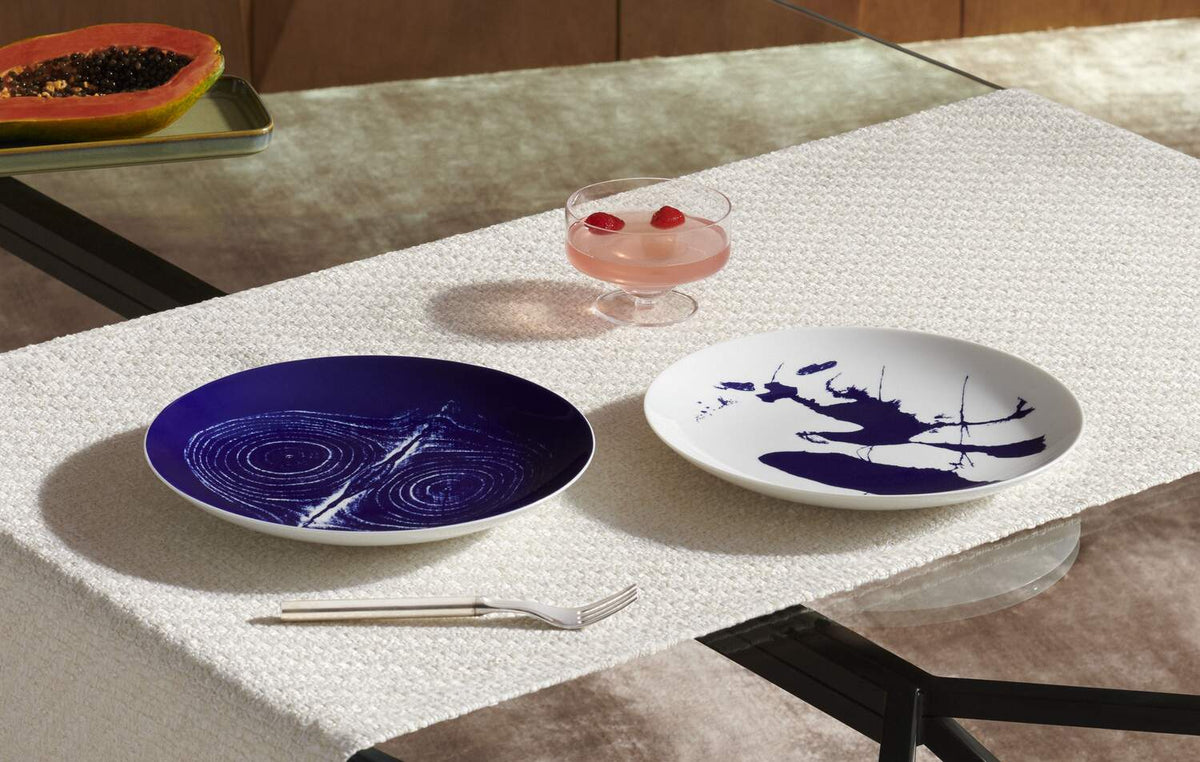 Assiettes Le Monde de Charlotte Perriand - Cassina-deux assiettes bleues sur un chemin de table-Cassina
