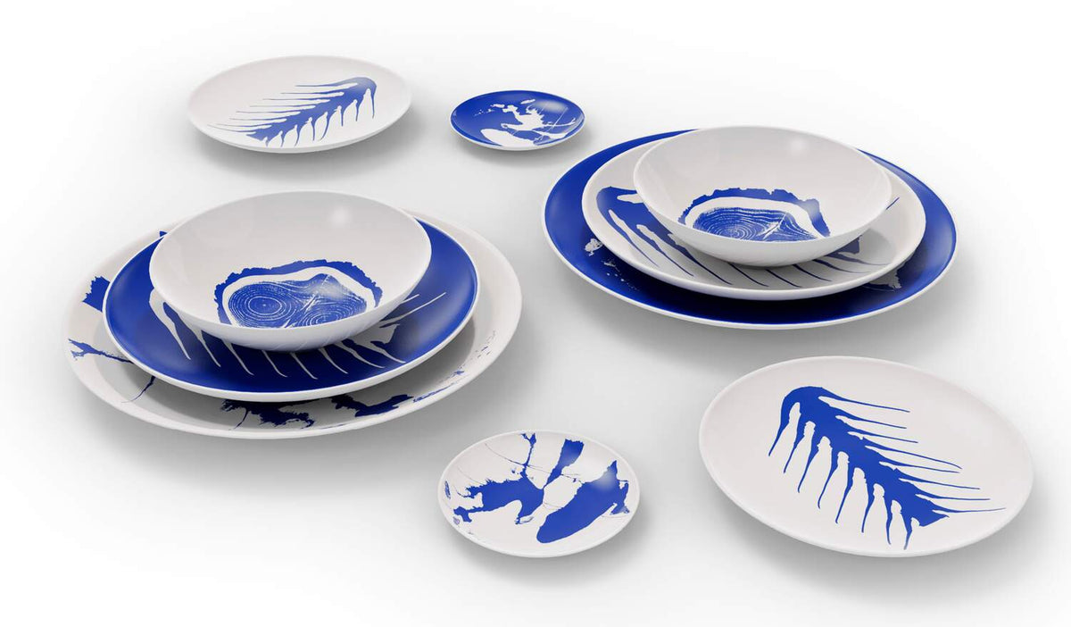 Assiettes Le Monde de Charlotte Perriand - Cassina-assiettes blanches à motifs bleus empilées et dispersées-Cassina