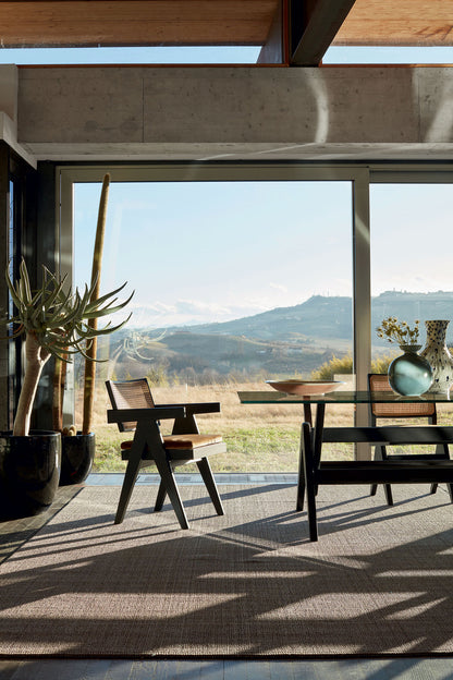 Table 056 Capitol Complex de Pierre Jeanneret - Cassina-fauteuil et banc noirs devant une baie sur les collines-Cassina