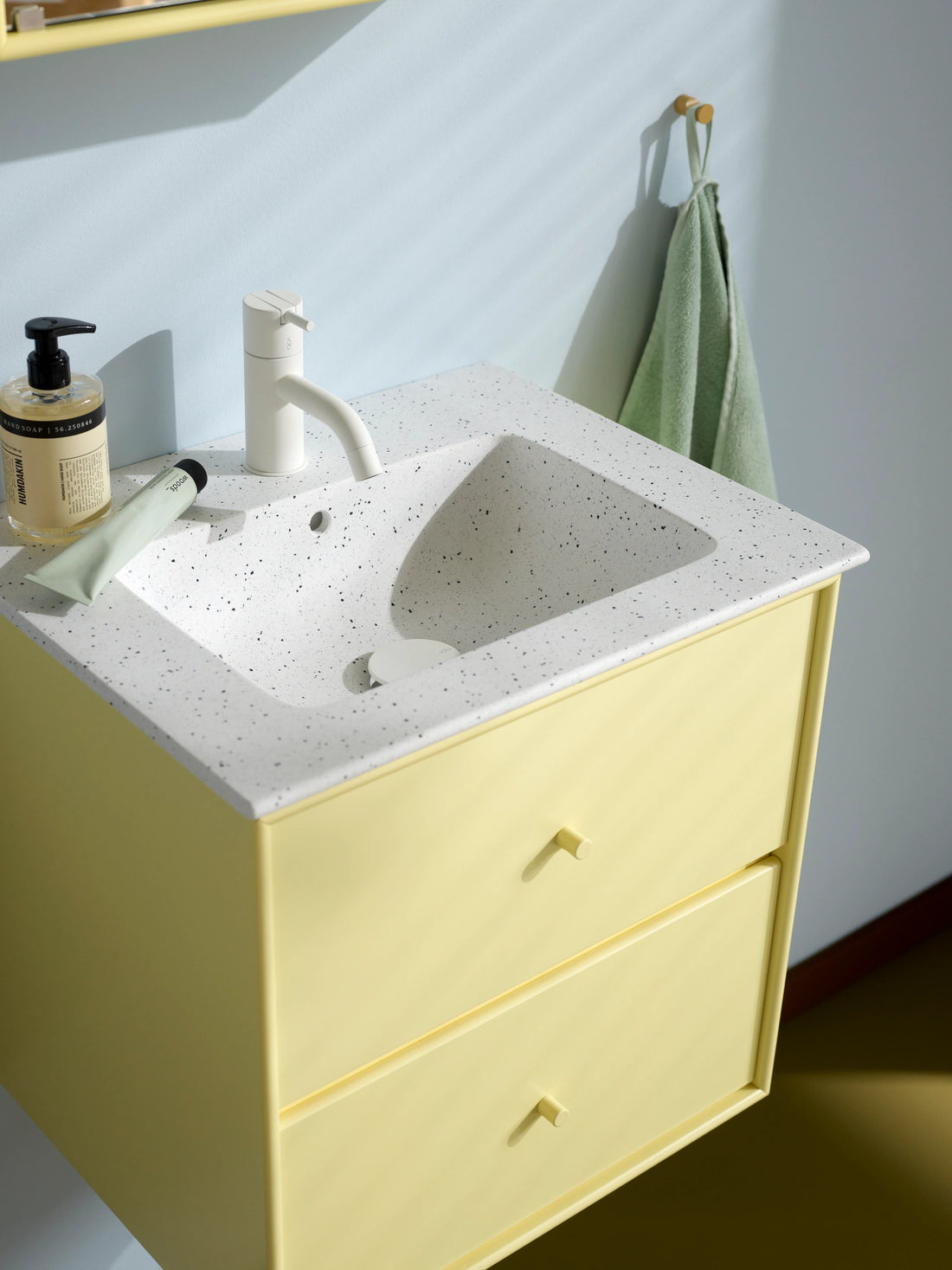 Meuble vasque Flow en situation : détail de la vasque White Large Grains du meuble Flow en Camomile, patères HOOK en Cumin