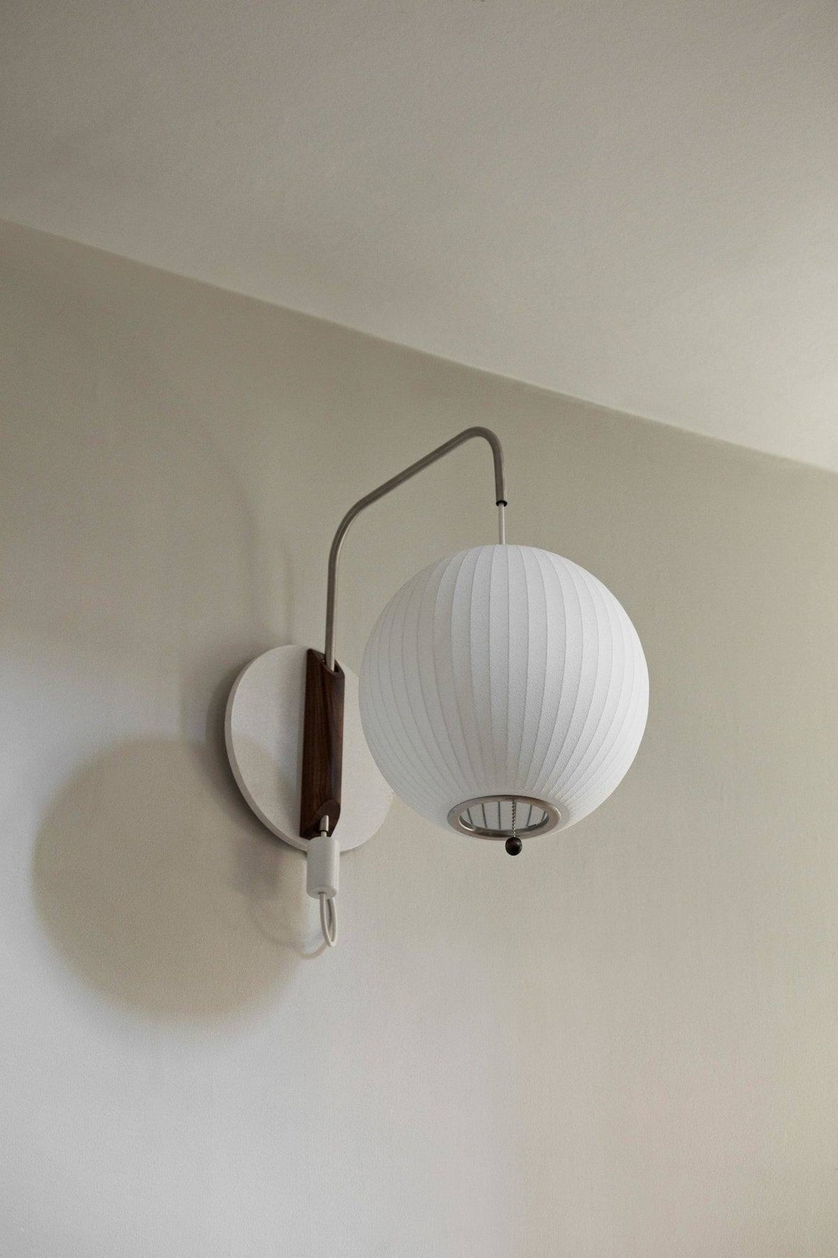 Applique murale "Ball Wall Sconce" de George Nelson - Hay-allumée sur un mur clair, vue rapprochée-The Woods Gallery